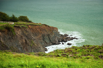 Horizontal view from path to Point Bonita Lighthouse on typical overcast, cloudy, foggy day at San Francisco Bay entrance, California, USA. Scenic stormy landscape of Pacific ocean. Travel, tourism
