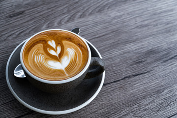 cup of hot cappuccino coffee on wooden background