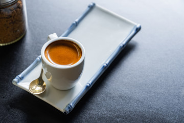 Fototapeta na wymiar cup of​ hot espresso coffee and on​dark​ table