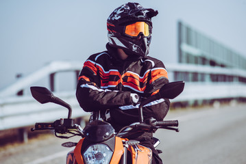 biker proud of his passion - solo motorbiker driving on an empty road  - single man trip with his...