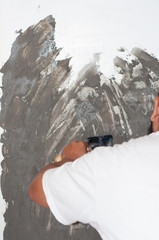 Applying gray decorative plaster on the wall. Interior Design, diy, home decoration concept.