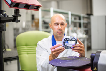 Quality engineer scanning some moldings component by professional optical 3D scanner, automotive...