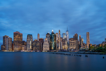 New York Financial District with skyscrapers and an old Brooklyn pier before sunrise