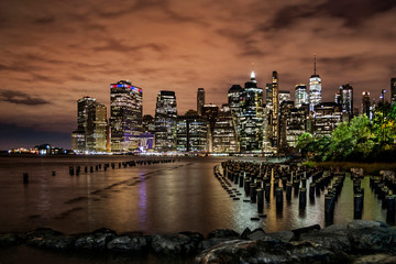 New York Financial District with skyscrapers and an old Brooklyn pier before sunrise