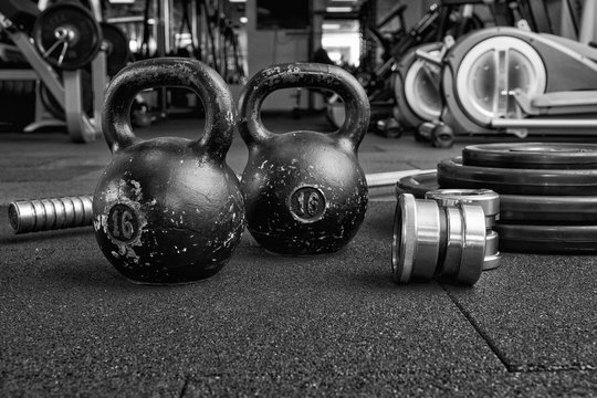 Dumbbells and kettlebells on a floor. Bodybuilding equipment. Fitness or bodybuilding concept background. Photograph taken from above, top view
