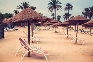 Focus on parasol. Sunbeds on snow-white sand