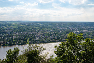 Obraz premium River Rhein in western Germany flowing along the city against the sky with clouds. Visible barges and ships on the river.