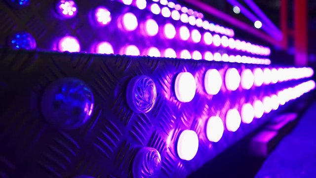 Staircase with colorful led lights. Illuminated steps. Bright lights illuminate the staircase of the attraction. LED lamps flicker. Entertainment. Evening outdoor activities. 