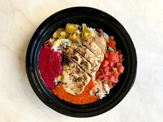 Take Away Jamaican Food Bowl with Chicken, Red Kidney Beans, Beet Sauce, Basmati Rice Pilaf, Avocado Guacamole, Jalapeno Pepper and Coconut Milk in Plastic Container Box / Package.