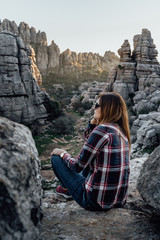 Fototapeta premium Young woman scout sitting, looking at the mountains. Concept of adventure, excursion and trips.