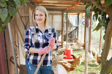 Young woman farmer caring for poultry