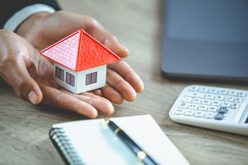 Orange house in the hands of business people, new home concept, future home, choose a future home, mortgage, real estate, tax, accounting for business people.