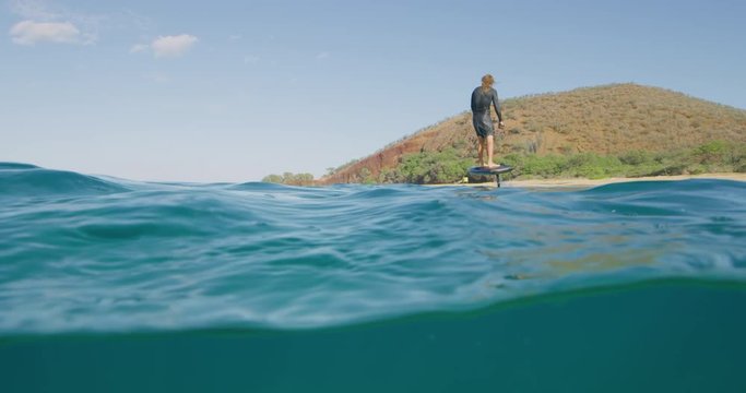 Young man riding an electric hydrofoil watercraft in the ocean, the future of ocean transportation is hydrofoils