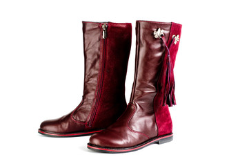 Women's leather boots in burgundy, fastened with a zipper. Background for women's shoes.