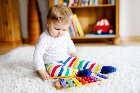 Adorable Cute Beautiful Little Baby Girl Playing With Educational Toys At Home Or Nursery. Happy Healthy Child Having Fun With Colorful Music Toy Xylophone Kid Learning Different Skills