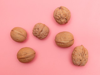 Walnuts on a pink background.