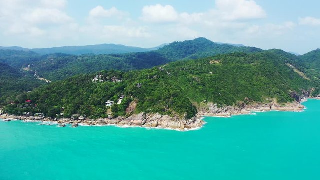 Koh Phangan coast. rocky shore, turquoise water lush reen jungle. Aerial panorama