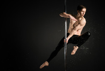 Portrait of professional male model performing a pole dance