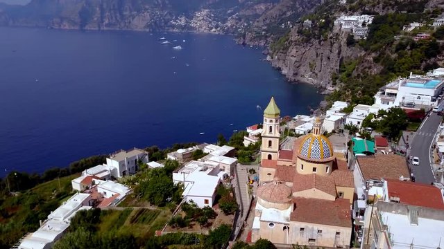 The Saint Gennaro church of Praiano town on the Amalfi coast in Italy, view of the dome and ocean cliffs, Aerial orbit reveal shot