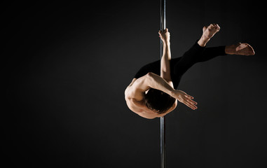 Portrait of professional male model pole dancing