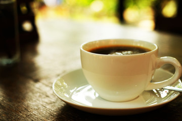 White cup of hot coffee on wood table