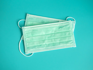 close up white surgical face mask on blue green background , equipment mask to protect man health from flu , a coronavirus infection , Health care concept