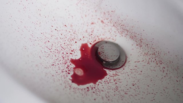 Closeup shot of blood dripping into sink.