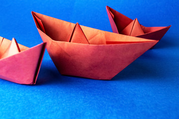 Paper red boats on a blue background