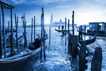 Venezianische Gondeln in Italien, Sonnenuntergang hinter der Kirche San Giorgio Maggiore. Klassische blaue Pantone 2020 Jahresfarbe. © smuki