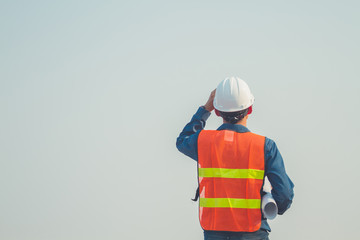 Obraz premium Engineer hold blue prints looking forward with hope and keep going at construction site.