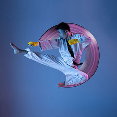Concept of motion and action in sport. Confident korean man in kimono practicing hand-to-hand...