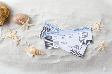Top view of airline tickets on the warm sand and starfish, shells.Concept of summer vacation, trip