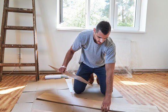 Handwerker oder Heimwerker beim Parkett verlegen