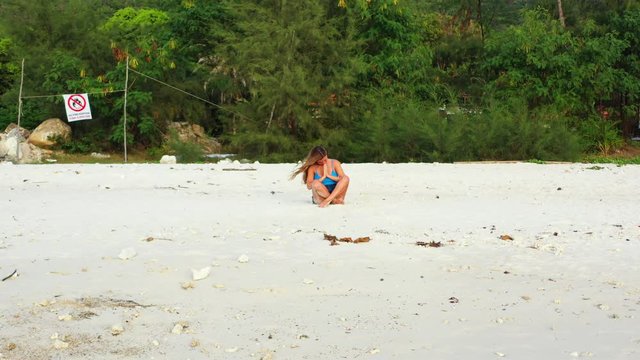 Caucasian pretty woman stretching and meditating on the wild sand beach, Thailand