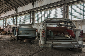 demolierte autos in einer halle hinten