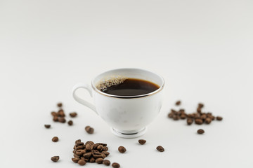 cup of coffee with beans on white background