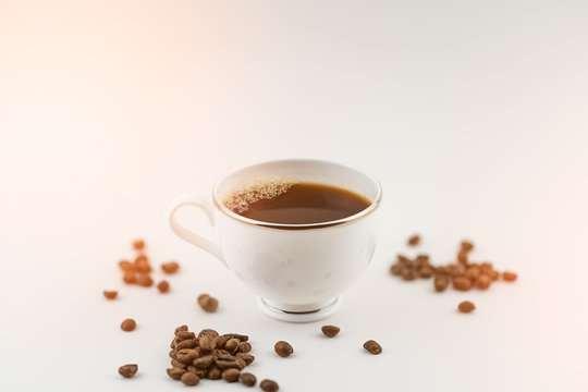 cup of coffee with beans on white background and flare