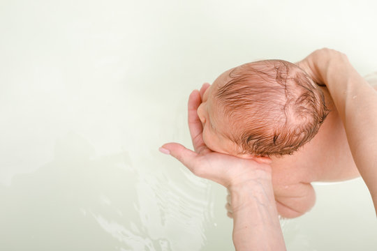 Mother Bathing Newborn Baby