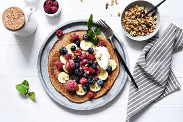 Crepe with berries and yogurt for breakfast. Breakfast on the kitchen table top view.