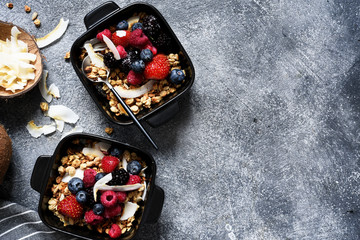 Granola with nuts, honey and berries for breakfast. Breakfast on the kitchen table, top view with place for text.