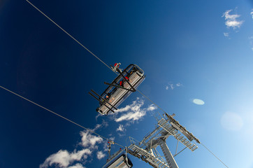 Fototapeta na wymiar skiers on ski-lift on a sunny day