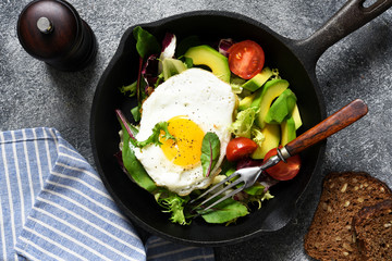 Salad with tomatoes and avocado, fried in a pan for breakfast.