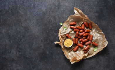 Bavarian sausages with sauce on a black background with place for text.