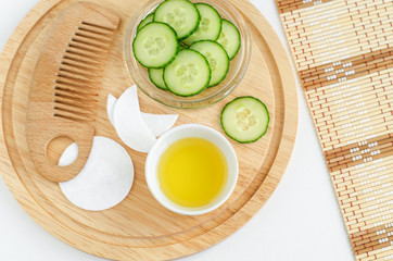 Olive oil, cucumber slices, cotton pads and eye patches and wooden hair comb. Ingredients for preparing homemade face and hair masks. Natural beauty treatment recipe and zero waste concept. Top view, 