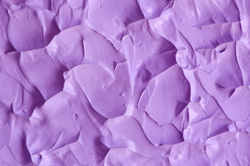 Purple facial cream (face mask, body wrap, hair conditioner) texture close up, selective focus. Lavender abstract background with brush strokes.