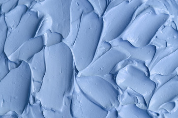 Obraz premium Light blue bentonite facial clay (mask, face cream, body wrap) texture close up, selective focus. Abstract background with brush strokes.