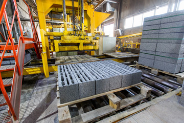 Industrial photography. A press machine for the manufacture of bricks from natural stone. Brick and...
