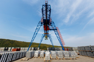 Cargo crane in a warehouse with natural brick under the open sky