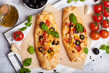 Delicious homemade filo pastry mini Pizza with chicken, tomatoes, black olives and cheese 