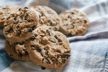 American chocolate cookies on blue cloth prepared for breakfast in the morning sunlight.